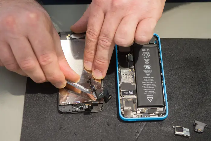 A worker repairs a smartphone. New York may soon make it illegal for phone manufacturers to deliberately restrict the ability to fix their products.